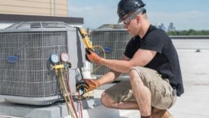 Sell Business A man working on an HVAC unit to maximize profit. Exit Advisor Business Broker