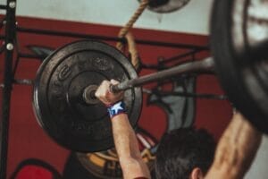 Sell Business A man lifting a barbell in a gym, showcasing the dedication and strength required for success in the gym business. Exit Advisor Business Broker