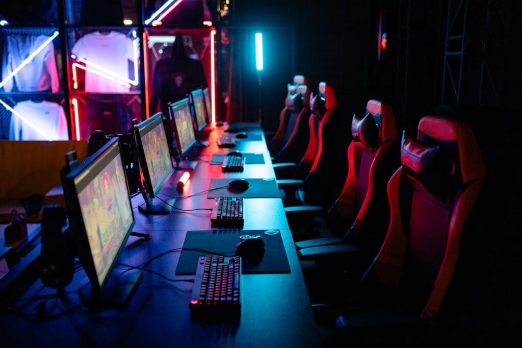How to Sell a E-Sports Business: 10 Advanced Tips for a High-Value Exit . Sell Business A row of computer monitors illuminated in a dark room, showcasing the high-value exit potential for an E-Sports Business looking to sell its assets. Exit Advisor Business Broker